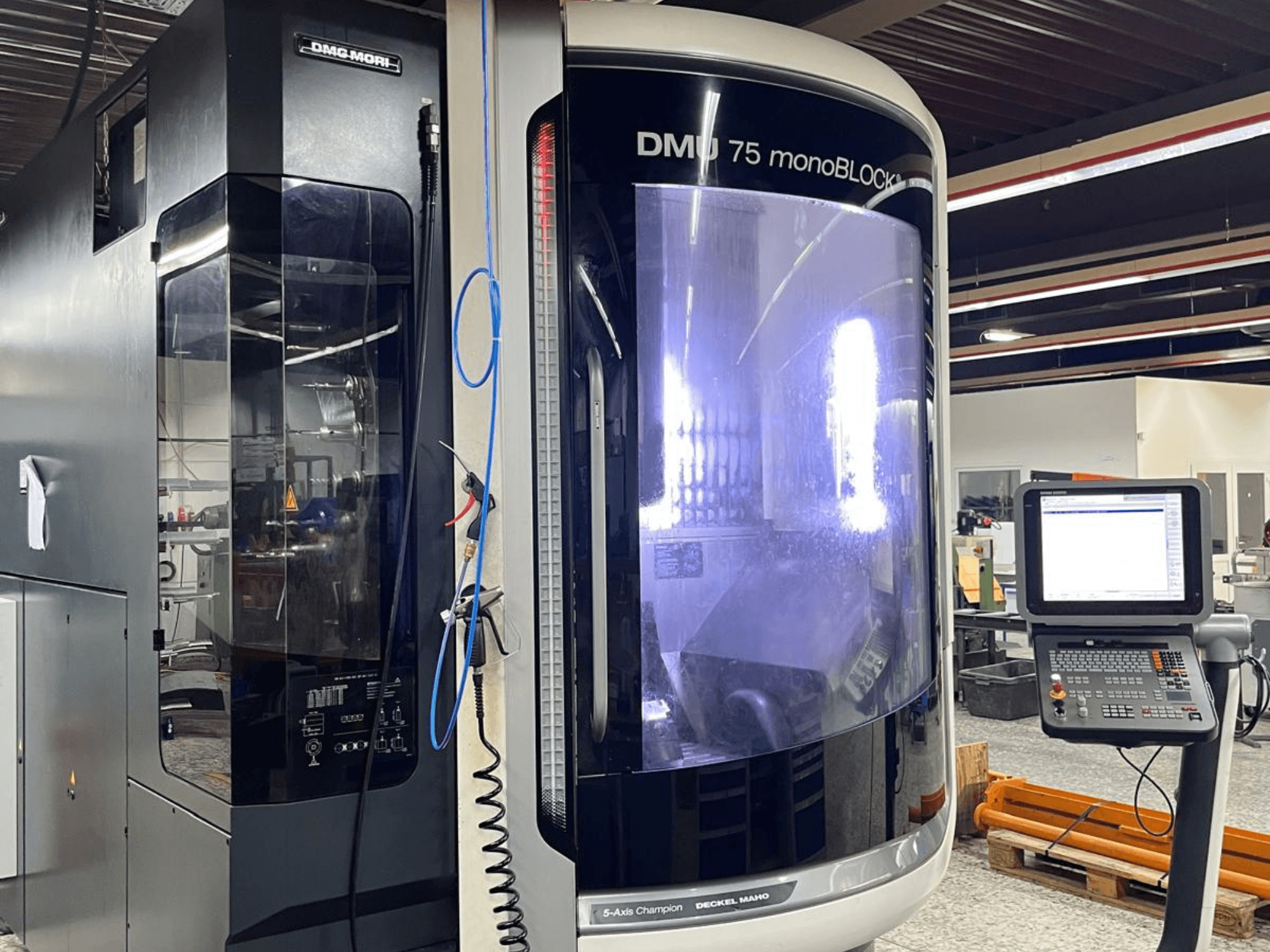 DMG MORI DMU 75 MonoBlock universālais apstrādes centrs, skats no priekšpuses, ar vadības paneli un atšķirīgu korpusu.