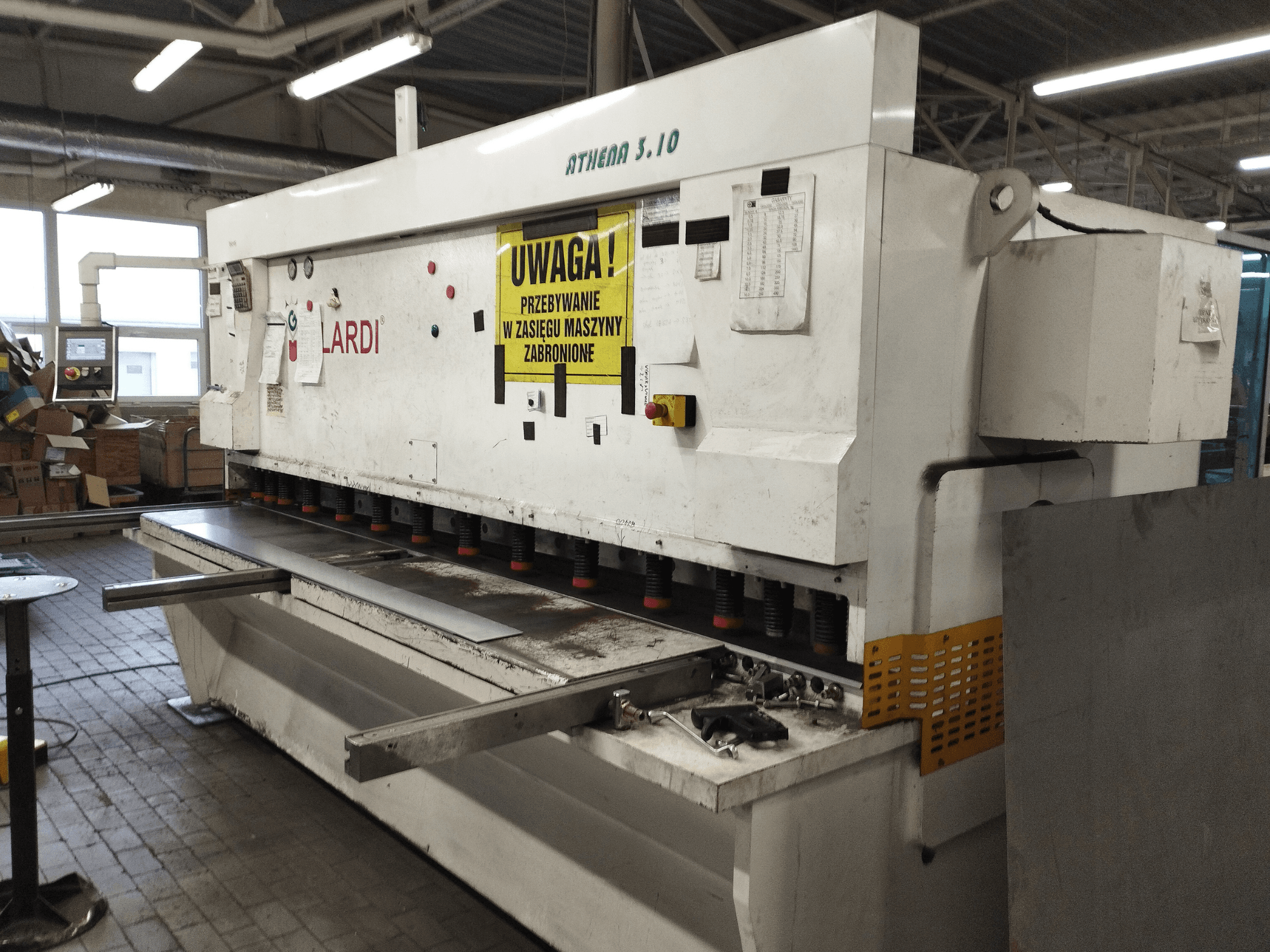 GILARDI ATHENA 3.10 CNC griešanas mašīna darbnīcā, skats no priekšpuses, kurā redzams vadības panelis un griešanas asmeņi.