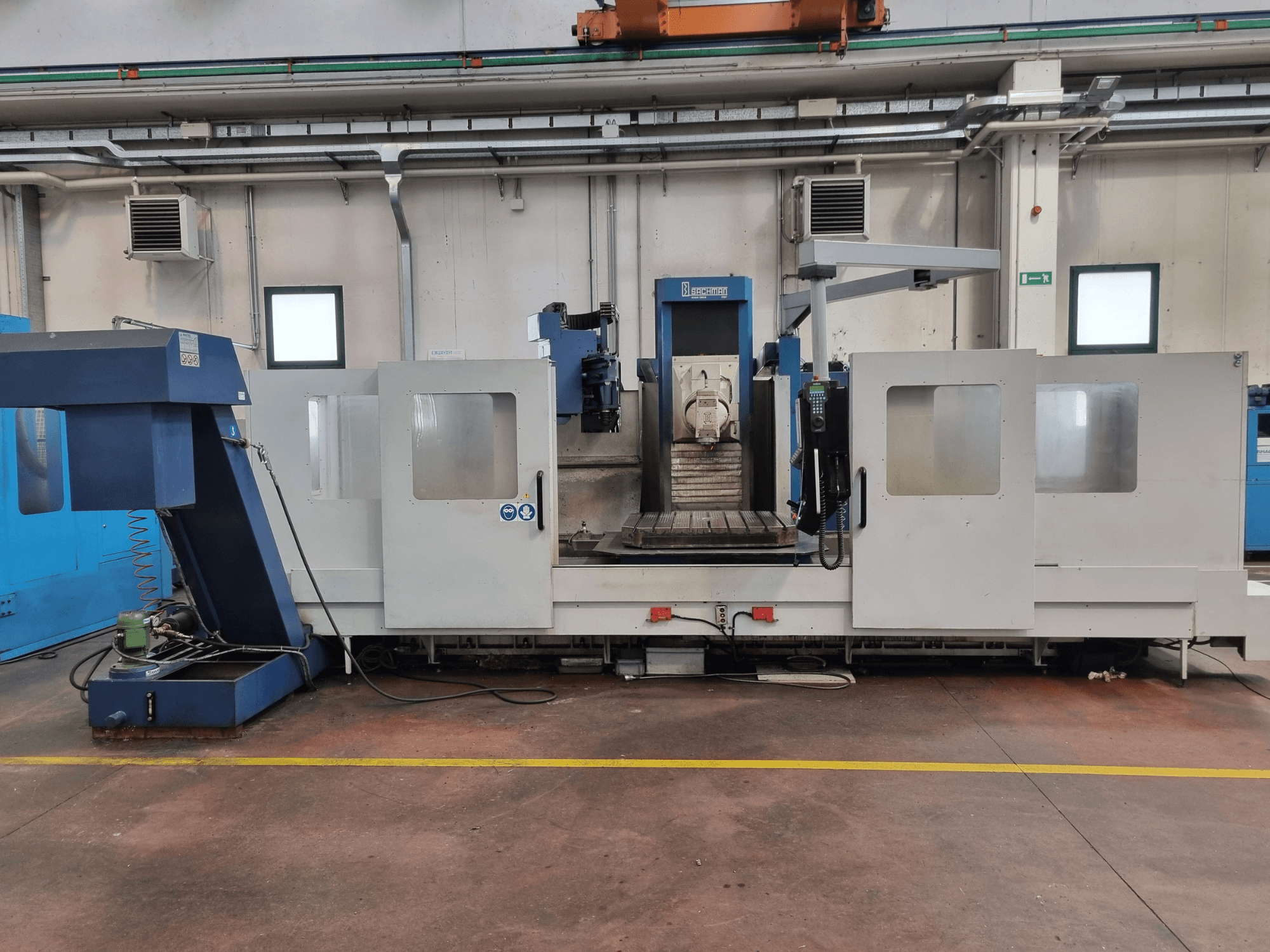 "Brembana" CNC frēzmašīna, sānu skats, kurā redzams vadības panelis un darba zona ar darba galdu iekšpusē.