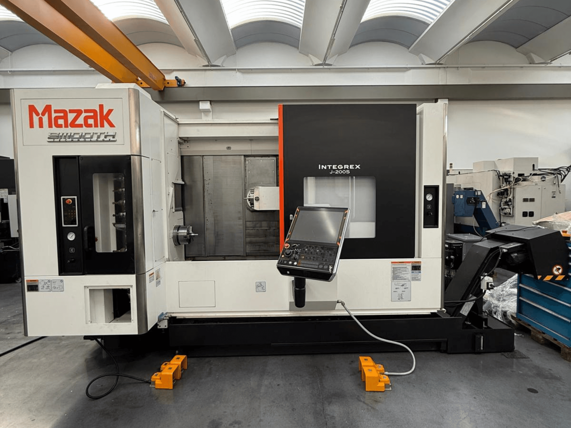 Mazak INTEGREX J-200 S frēzēšanas-apgriešanas centrs no priekšpuses, ar vadības paneli un apstrādes zonu, novietots uz rūpnīcas grīdas.