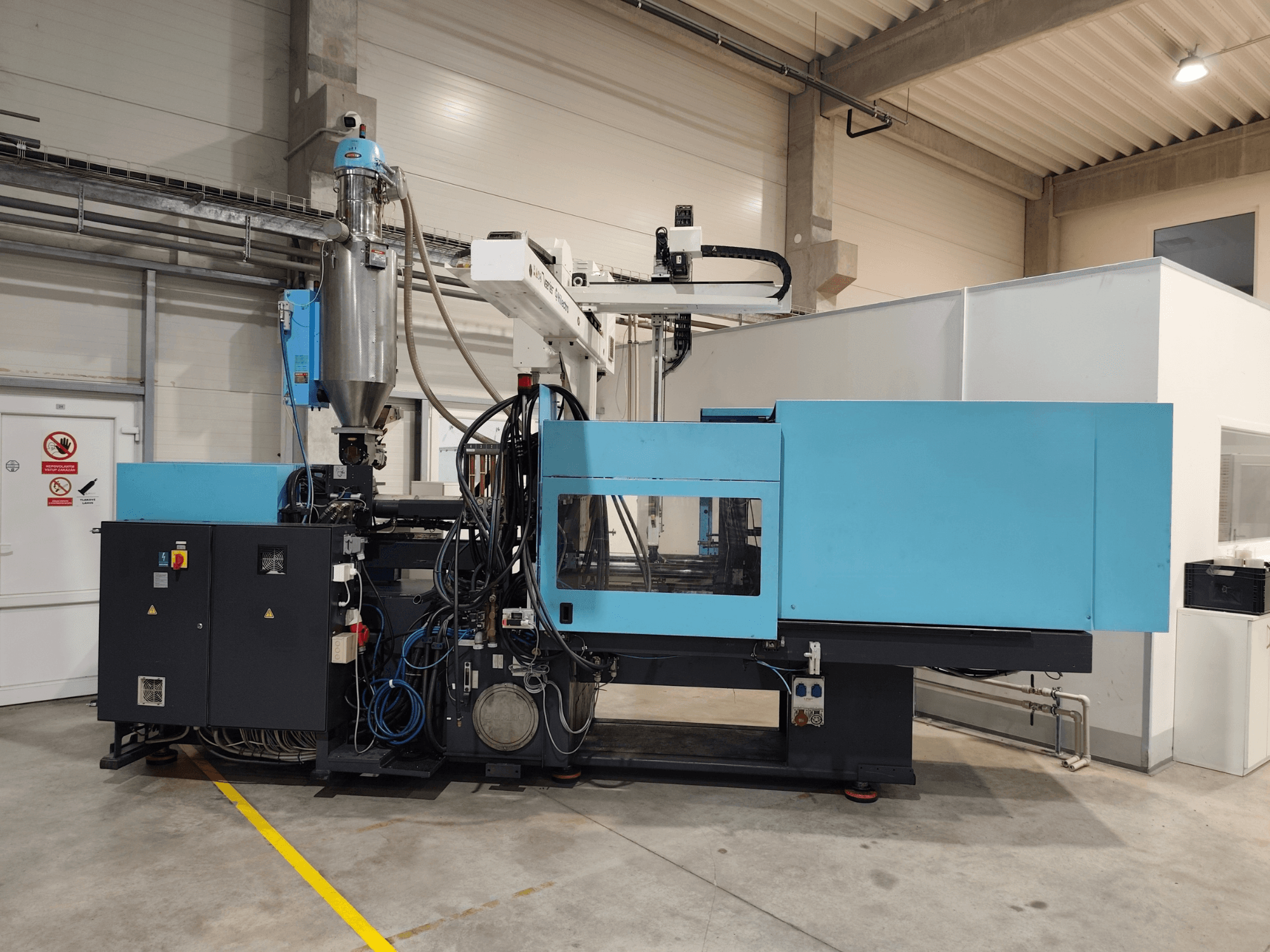 DEMAG Ergotech Extra 160-430 hidrauliskās plastmasas liešanas mašīnas skats no priekšpuses, kurā redzams vadības panelis un padeves tvertne.