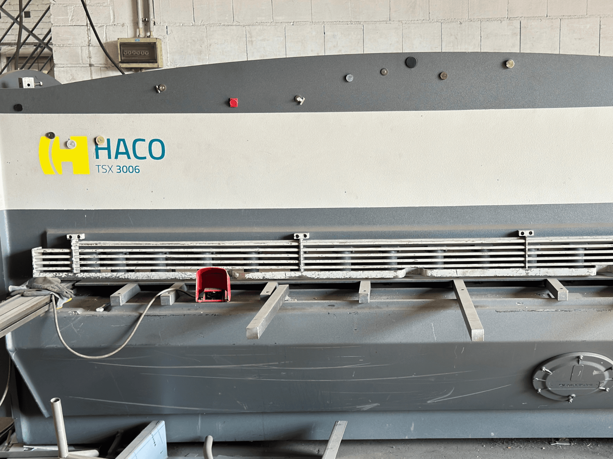 HACO TSX3006 MOT hidrauliskās šķēres, skats no priekšpuses, ar metāla griešanas asmeņiem un vadības paneli, ar darbības detaļām.