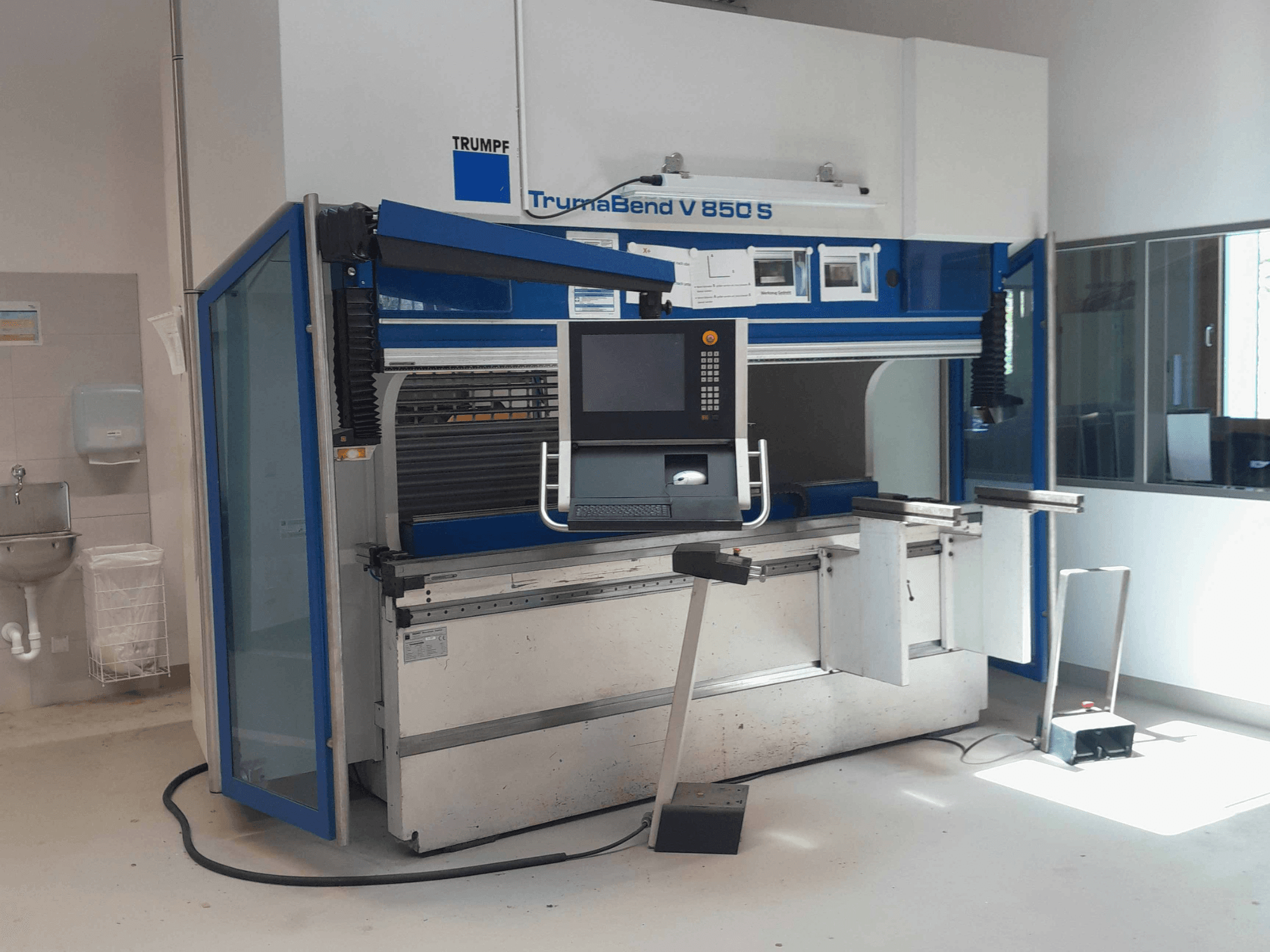 TRUMPF TrumaBend V 850 S lieces preses skats no priekšpuses ar vadības paneli un drošības elementiem gaišā darba telpā.