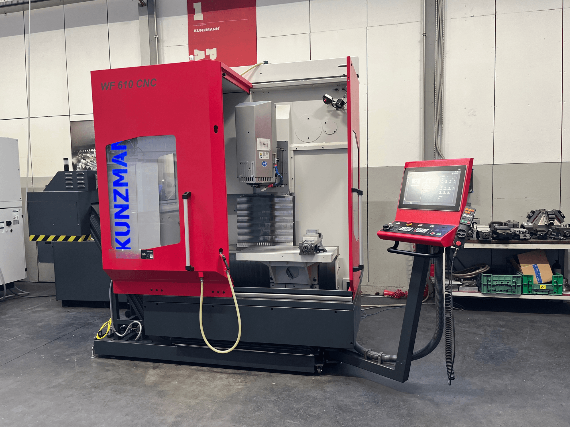 KUNZMANN WF 610 CNC vertikālais apstrādes centrs darbnīcā, kurā redzams vadības panelis un mašīnas detaļas.