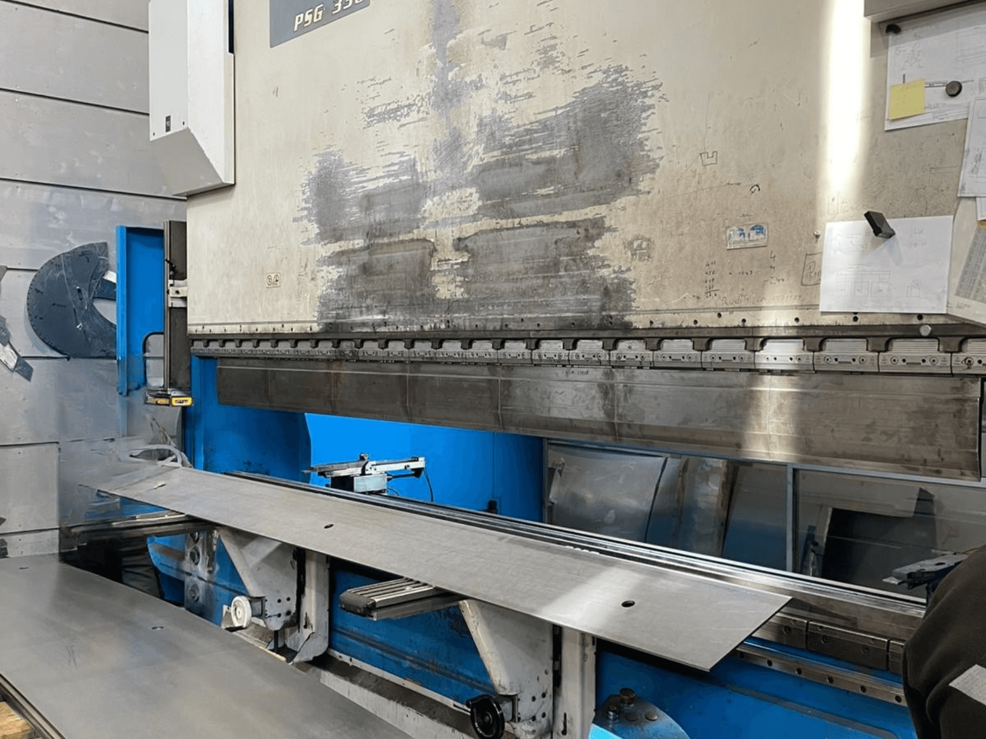 GASPARINI PSG 330/4000 Variante C preses bremze darbnīcā, parādīta lieces zona ar metāla loksnēm un iekārtu vadības ierīcēm.
