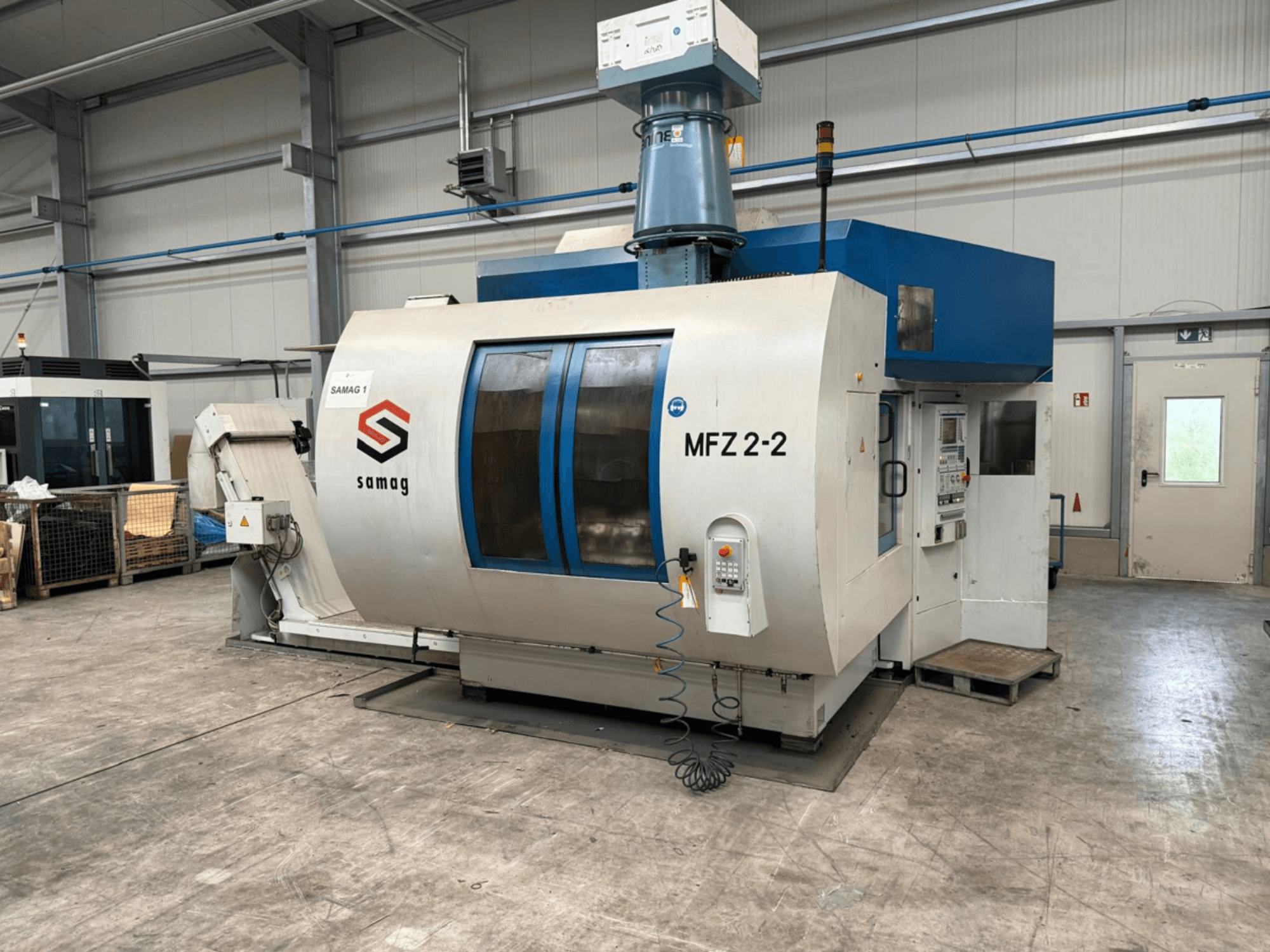 Samag MFZ 2-2 darbgalds, priekšējais skats, redzams vadības panelis un zilā virsma, ar drošības funkcijām rūpnieciskā vidē.