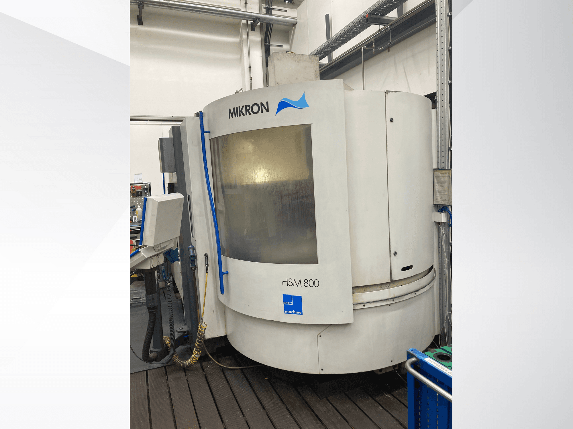 Mikron rISM 800 CNC darbagalds, priekšējais skats ar vadības paneli, cilindrisks dizains un zili akcenti, darbnīcas vide.