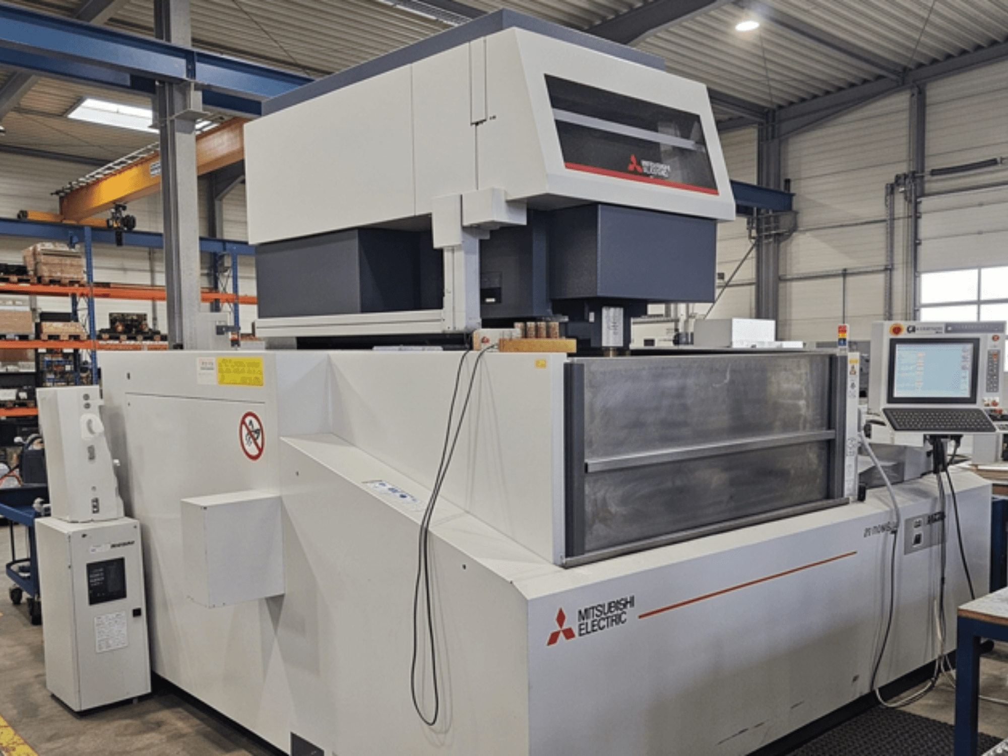 Mitsubishi MV-4800 stiepļu elektroerozijas mašīna, skats no priekšpuses, kurā redzams vadības panelis un darba zona rūpnīcas vidē.