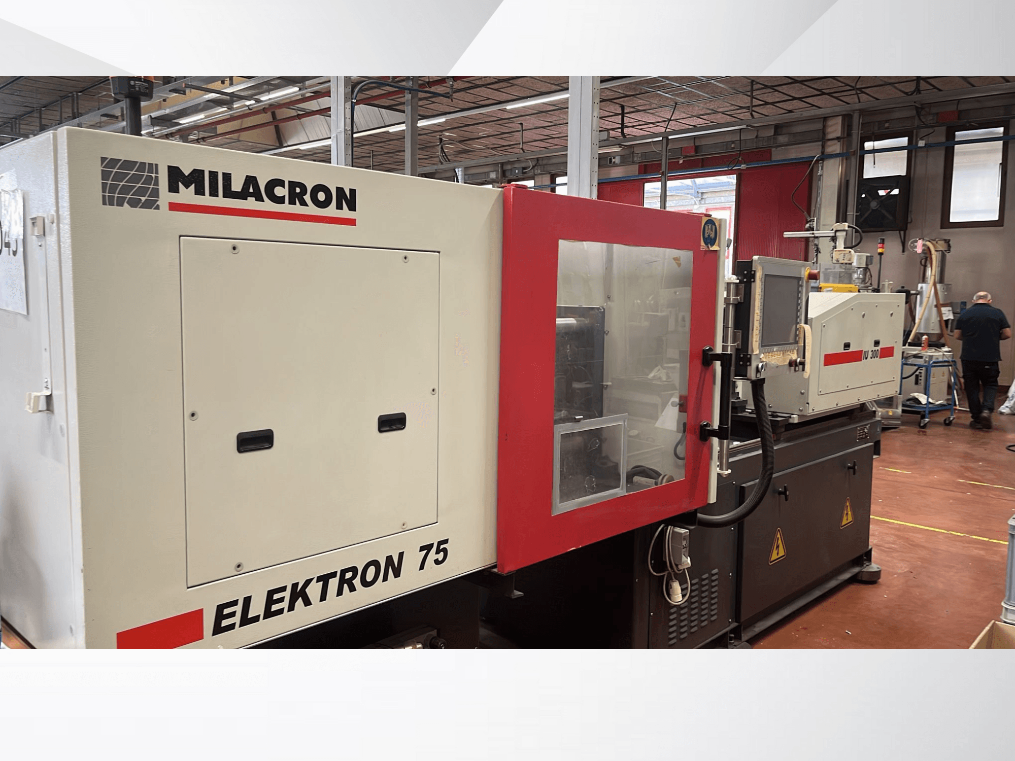 Milacron Elektron 75 iesmidzināšanas veidošanas iekārta darbnīcā, sānu skats, kurā redzams vadības panelis un mehāniskās detaļas.