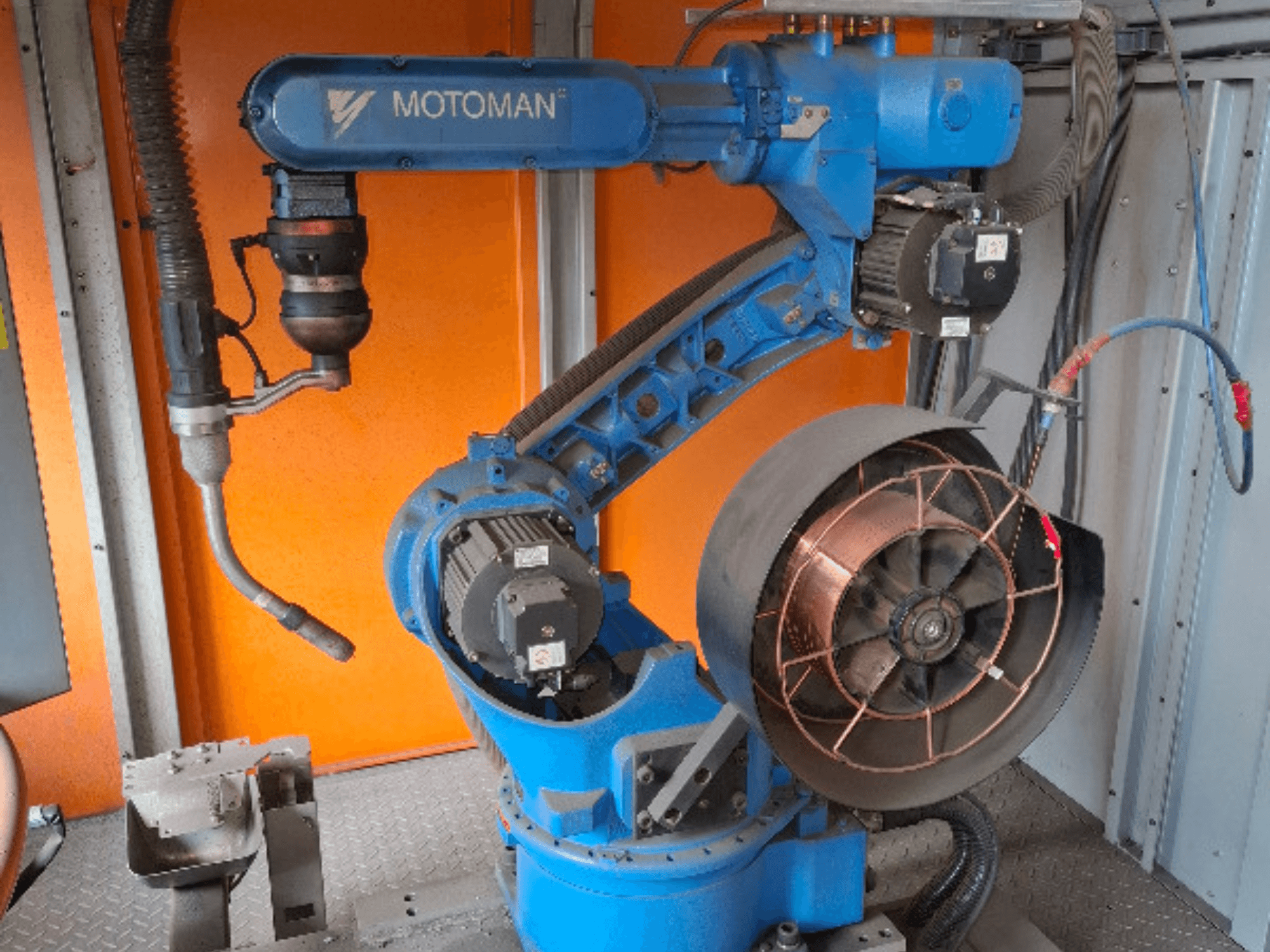 MOTOMAN robotizētā roka zilā krāsā, skats no sāniem, ar pievienotu ventilatoru un instrumentiem, parādītas mehāniskās detaļas un savienojumi.