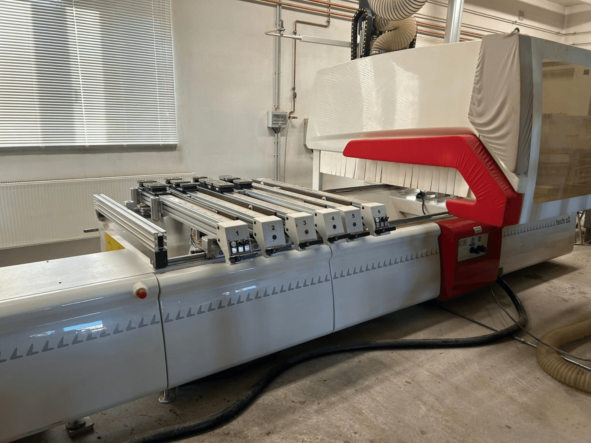 SCM TECH Z2-27-C koka urbjmašīna, skats no sāniem, redzams vadības panelis un sliedes, ar sarkanbaltiem dizaina elementiem.