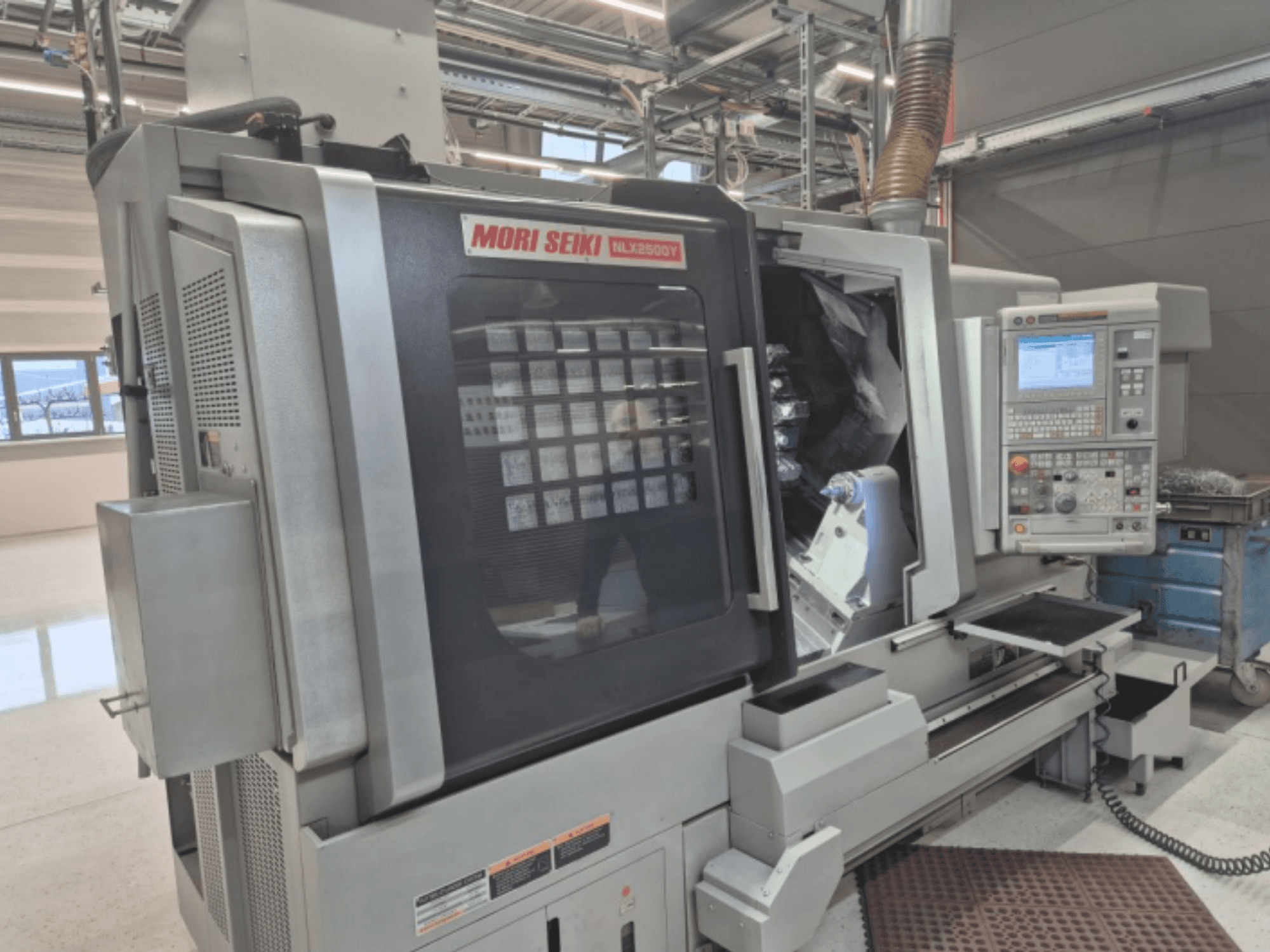 MORI SEIKI NL2500Y CNC virpmašīna rūpnīcā, priekšējais skats, kurā redzams vadības panelis un sagataves kamera.