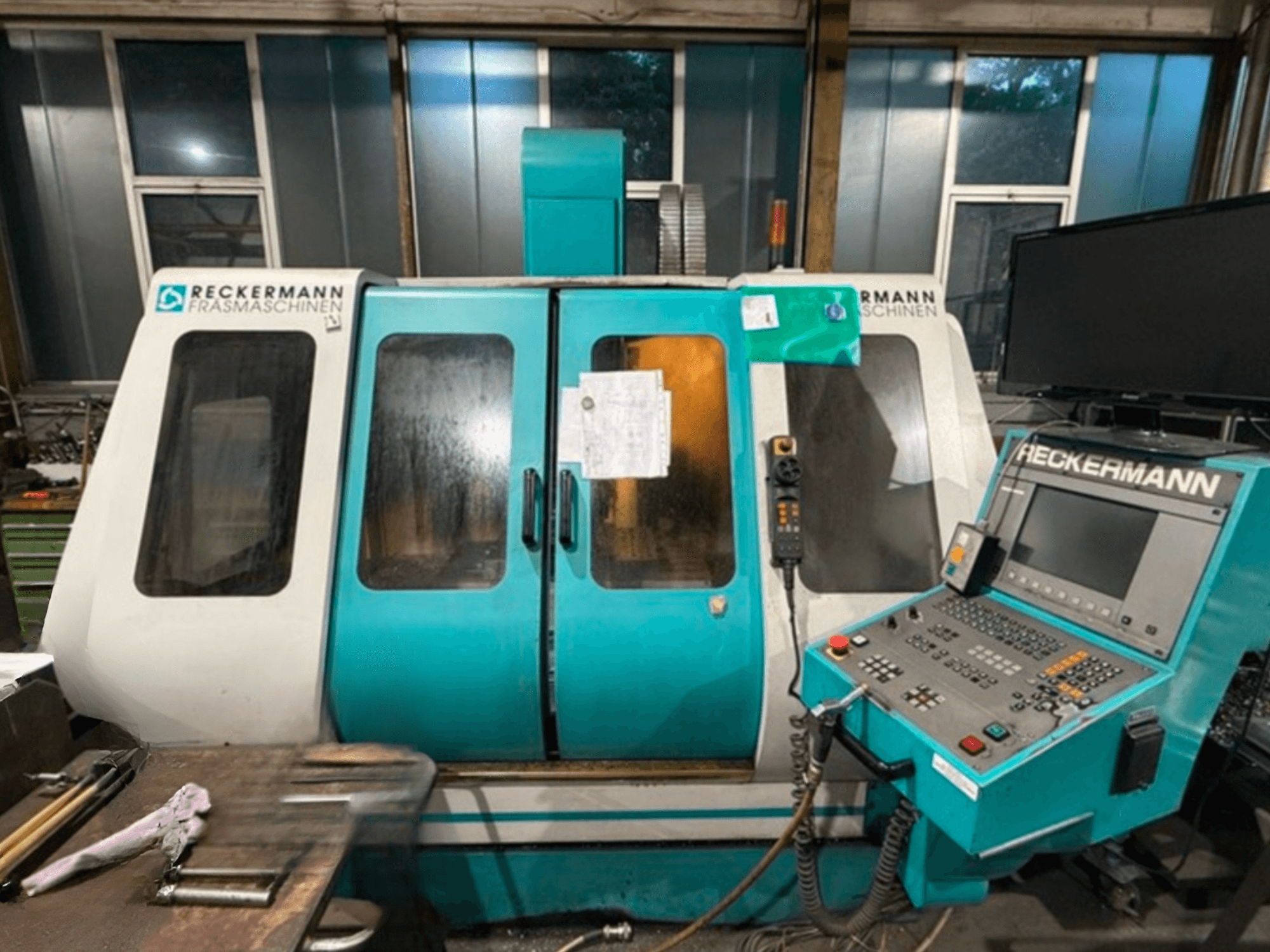 RECKERMANN VMC 850 universālais apstrādes centrs, priekšējais skats, kurā redzams vadības panelis un stikla durvis.