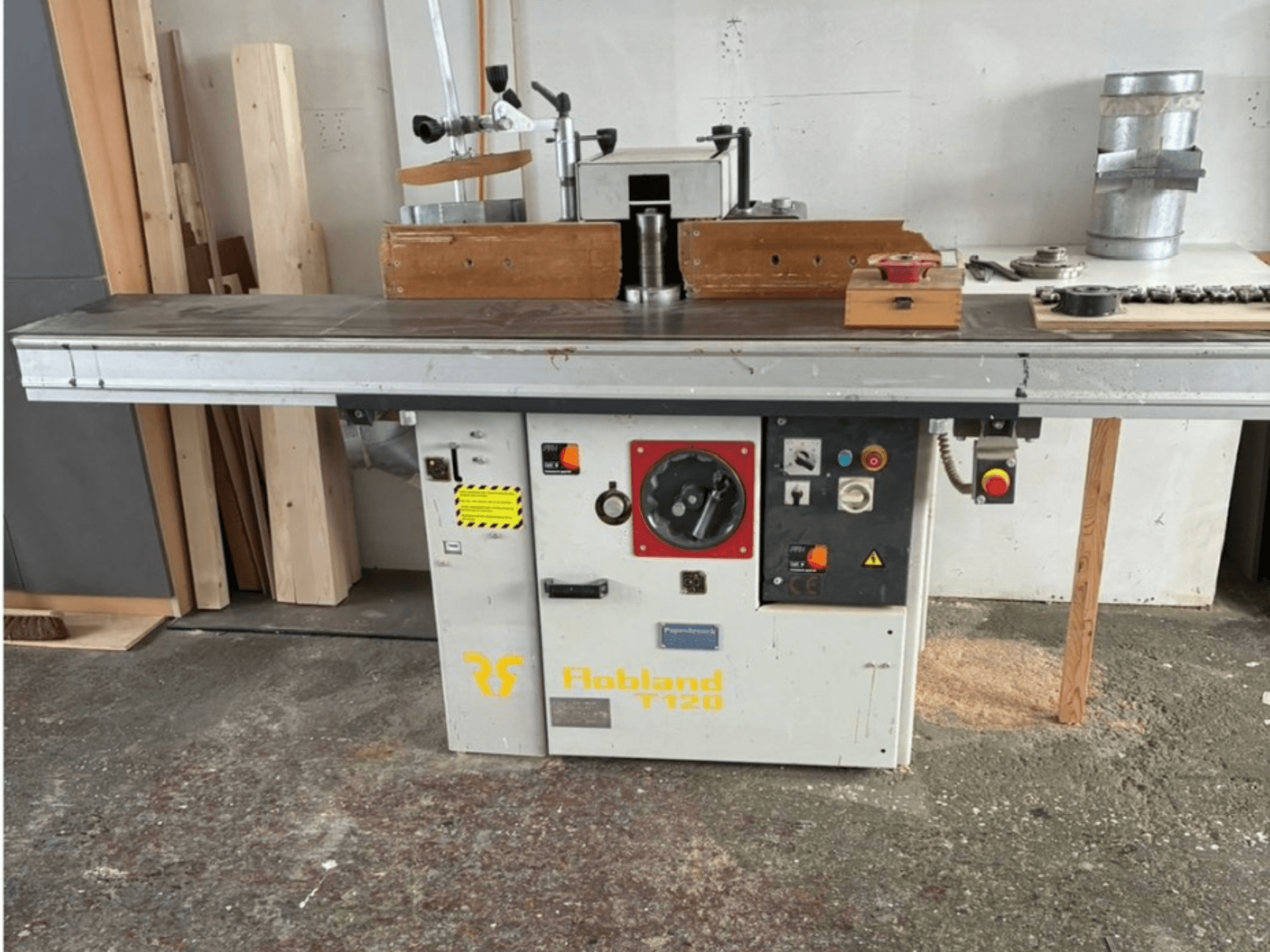 Hobbland T120 galda ēvele, skats no priekšpuses, ar sudraba virsmu, vadības paneli ar pogām un drošības marķējumu.